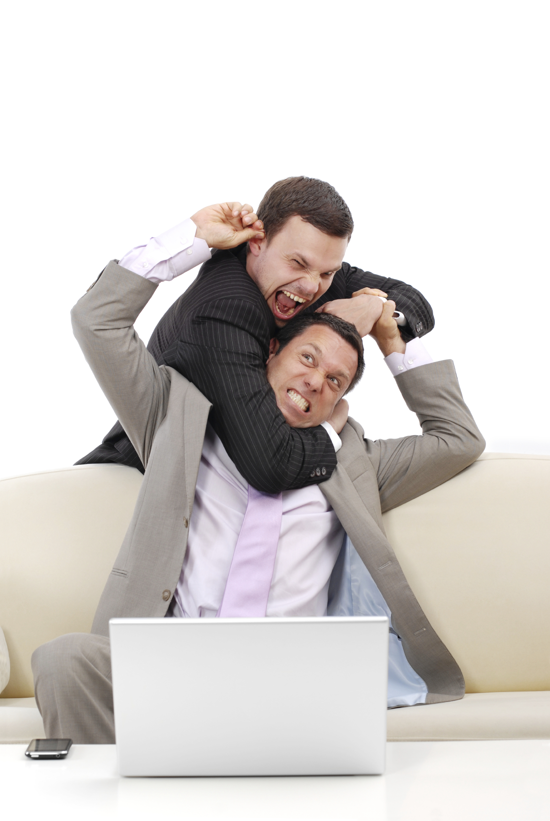 Two businessmen fighting on a couch in front of a laptop